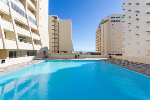 a swimming pool in the middle of two buildings at Water Green House - Praia da Rocha in Portimão