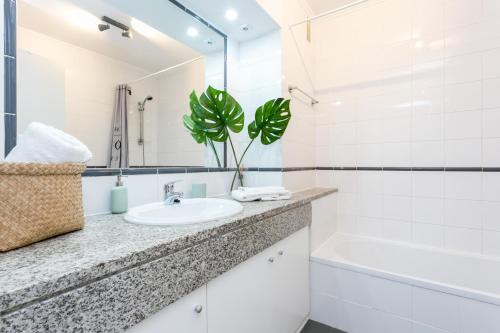 a white bathroom with a sink and a bath tub at Water Green House - Praia da Rocha in Portimão