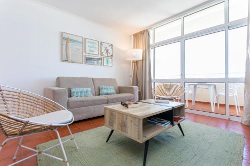 a living room with a couch and a table at Water Green House - Praia da Rocha in Portimão