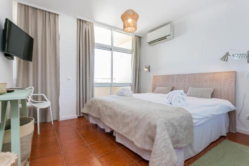 1 dormitorio con 1 cama y TV en Water Green House - Praia da Rocha en Portimão