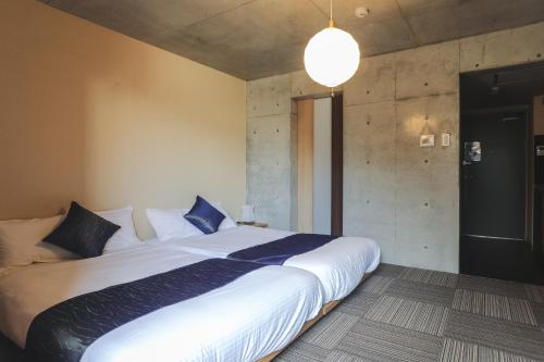 a bedroom with a large white bed with blue pillows at Naganoya in Kyoto