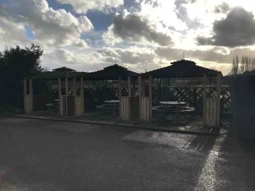 a pavilion with tables and umbrellas on a street at The Black Bull Inn in Fyfield