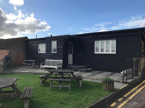 a house with a picnic table and benches in the yard at The Black Bull Inn in Fyfield