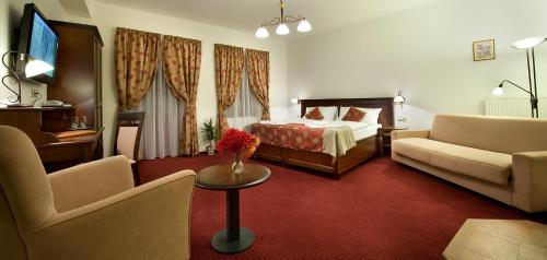 a hotel room with a bed and a couch and a table at Hotel Joseph 1699 in Třebíč