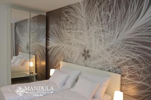 a bedroom with a bed with a large wall mural at Mandula Apartman in Cegléd