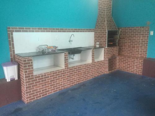 a kitchen with a brick wall and a sink at Pousada Ilha do Sol in Salinópolis