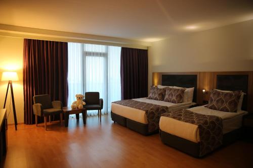 a hotel room with two beds and a teddy bear at Euphoria Apartments in Batumi
