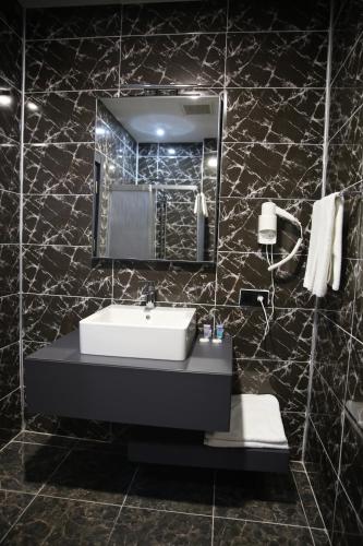 a bathroom with a sink and a mirror at Euphoria Apartments in Batumi