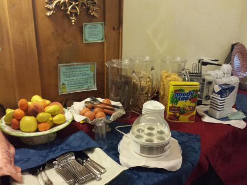 a table with a bowl of fruit and a bowl of food at Hotel Ortles Dolomiti Walking & Spa in Cogolo