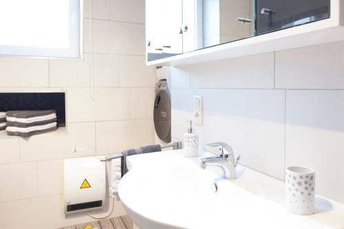 a white bathroom with a sink and a mirror at La Renaissance 1&2 high standing guest house in Herve