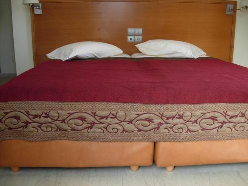 a large bed with a wooden headboard and two pillows at Philippos Studios & Apartments in Kardamaina