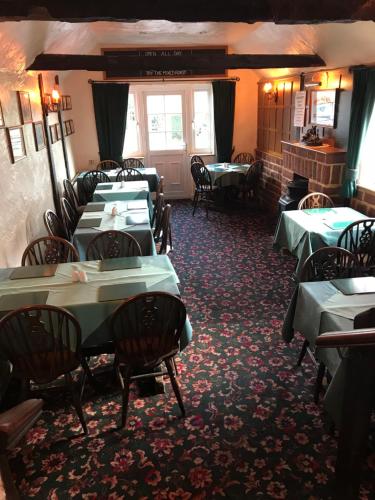 uma sala de jantar com mesas e cadeiras num restaurante em The Black Bull Inn em Fyfield