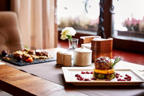 a table with a plate of food on a table at Grand Hotel Stamary in Zakopane