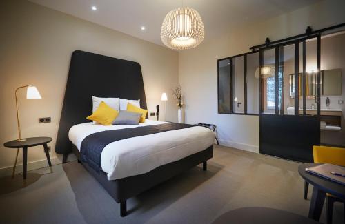 a bedroom with a large bed with yellow pillows at Pont du Chalon Hôtel and Restaurant in Margès