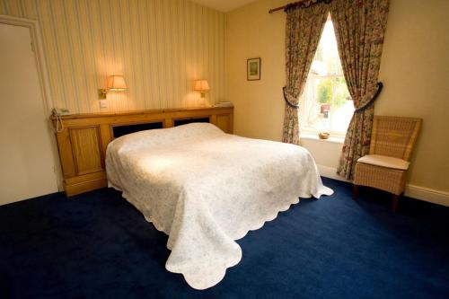 a bedroom with a white bed and a window at Calf's Head Hotel in Clitheroe