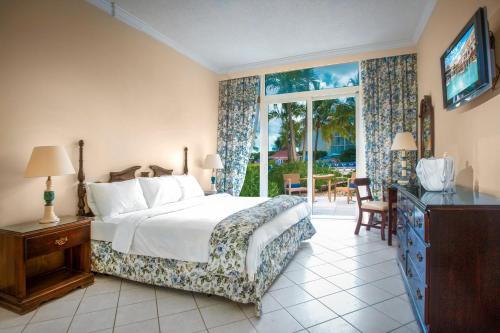 a bedroom with a bed and a tv and a window at Breezes Resort & Spa All Inclusive, Bahamas in Nassau