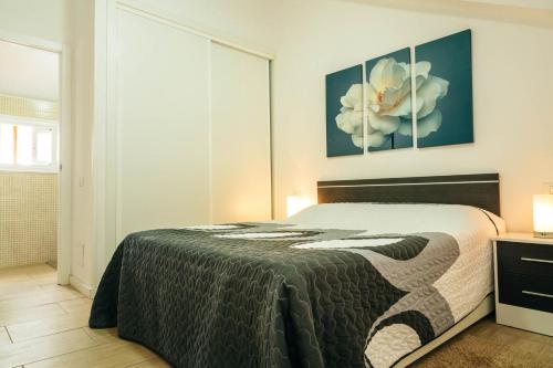 プラヤ・デ・ラス・アメリカスにあるParque Santiago I Duplexのベッドルーム1室(ベッド1台付)が備わります。壁には絵画2点が飾られています。