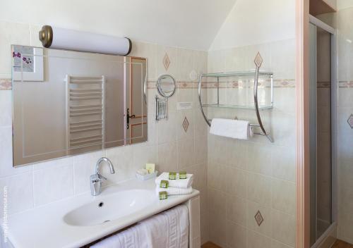 a white bathroom with a sink and a shower at Le Chalet Montégut in Moulins