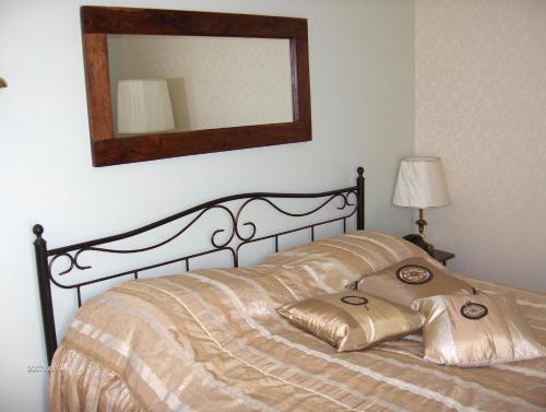 a bedroom with a bed with a mirror on the wall at Hotel Centras in Šakiai