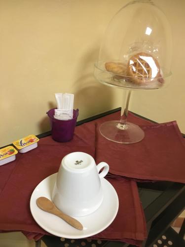 a white teapot on a plate on a table at B & B La Guesthouse in Poirino