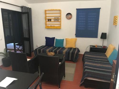 a living room with a couch and a table at T0 Pedras D'el Rei in Tavira