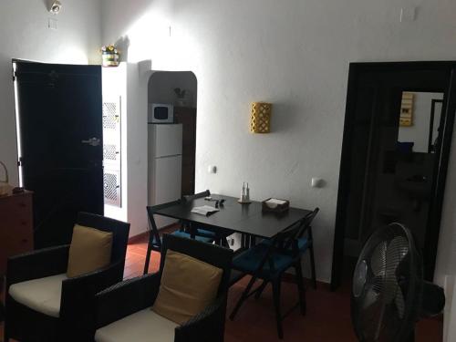 タヴィラにあるT0 Pedras D'el Reiのテーブルと椅子、キッチンが備わる客室です。