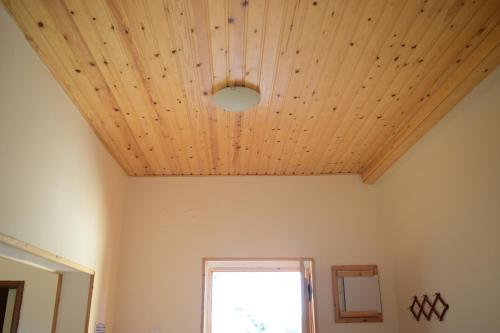 a room with a wooden ceiling and a window at White Lake Holiday House in Elafonisi