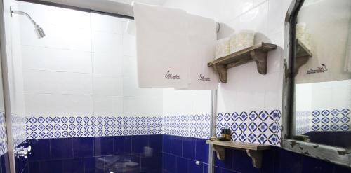 a bathroom with a blue and white tiled wall at Alondra Hotel Boutique in Mineral del Monte
