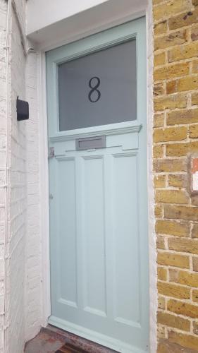a white garage door with the number eight on it at Seaview Cottage in Broadstairs