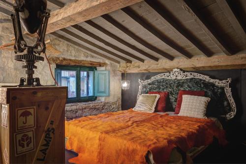 a bedroom with a bed with an orange bedspread at Zona Pedonale - RoughLuxe Home in Arezzo