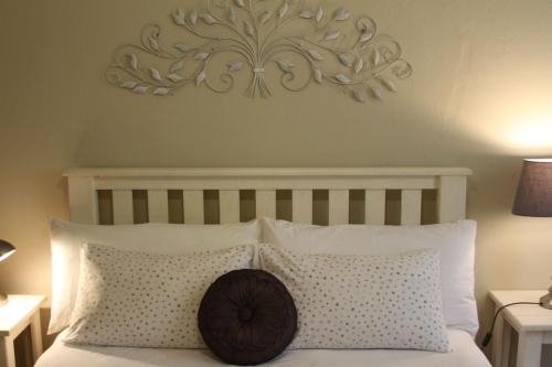a bedroom with a bed with a wooden headboard and pillows at Ripple Hill Hotel in Patensie