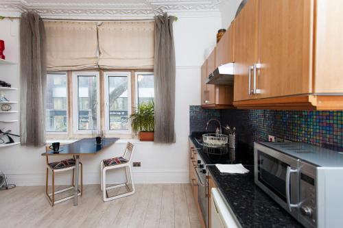 a kitchen with wooden cabinets and a counter top at ItalianFlat - Shaldon in London