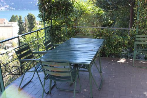モルトラージオにあるCharming Villa with Lake view in Moltrasioの緑のテーブルと椅子が備わるバルコニー