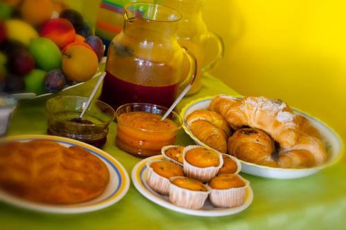 a table topped with plates of bread and pastries at Lirma B&B in Cefalù