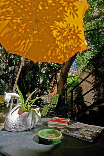 a table with a vase and a yellow umbrella at Lirma B&B in Cefalù