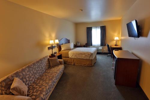 a hotel room with a bed and a couch at Sandhills Guest House Motel in Atkinson