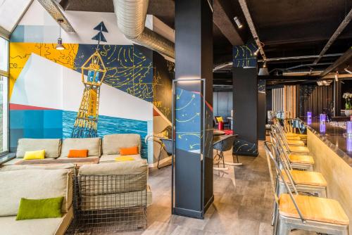 a room with couches and a mural of a tower at Mercure Le Havre Centre Bassin Du Commerce in Le Havre