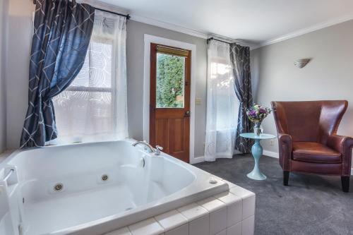 a large bathroom with a tub and a chair at Wild Iris Inn in La Conner