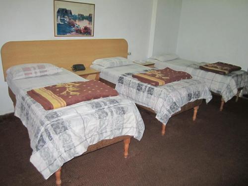 a room with three beds with blankets on them at Asia Hotel in Amman