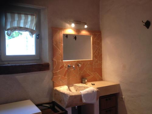 une salle de bain avec un lavabo et un miroir dans l'établissement Les Gîtes de l'Astrée, à Saint-Bris-des-Bois