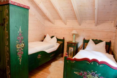 a bedroom with two beds in a room with wooden walls at Gasthof Bischofsmühle in Helmbrechts