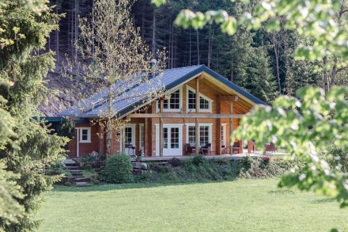 a log cabin in the woods with a yard at Gasthof Bischofsmühle in Helmbrechts