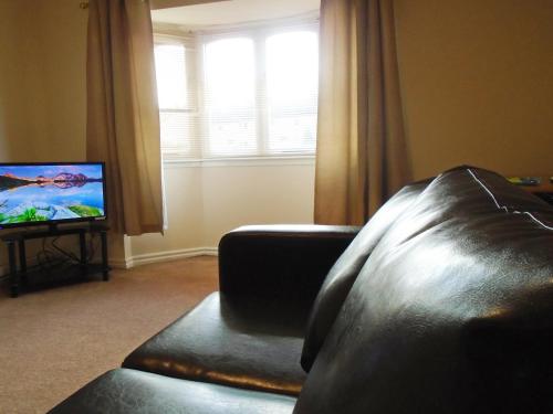 Televízia a/alebo spoločenská miestnosť v ubytovaní Clydebank Apartment