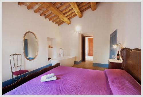 1 dormitorio con cama morada y bañera en Agriturismo Rosso di Sera, en Cugnoli