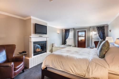 a hotel room with a bed and a fireplace at Wild Iris Inn in La Conner