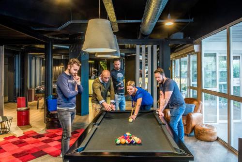 a group of men standing around a pool table at Mercure Le Havre Centre Bassin Du Commerce in Le Havre