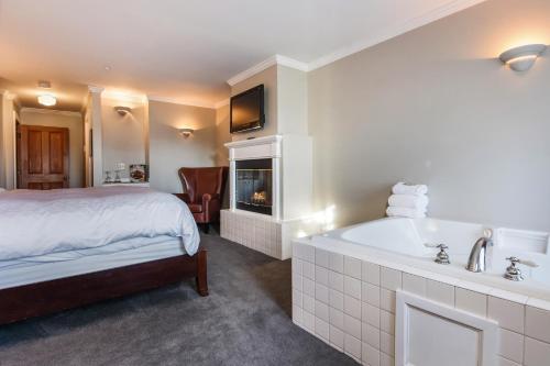 a hotel room with a bed and a bath tub at Wild Iris Inn in La Conner