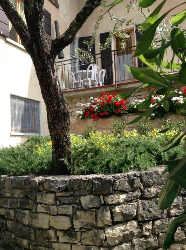 a stone wall with a tree in front of a building at Appartamento Colombere Priori Elisabetta in Malcesine