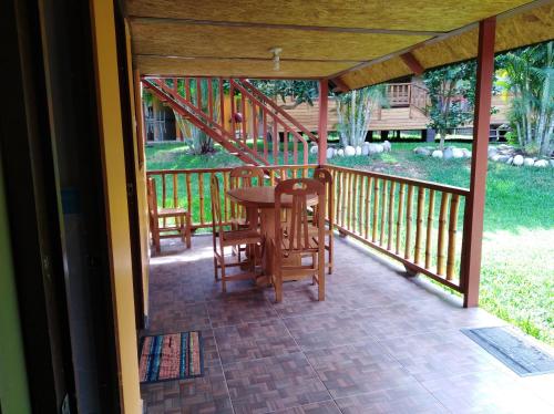 a porch with a table and chairs on it at Ecolodge Don Felix in Quillabamba