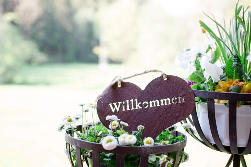 two baskets filled with flowers and a sign that reads willuminati at Gasthof Bischofsmühle in Helmbrechts